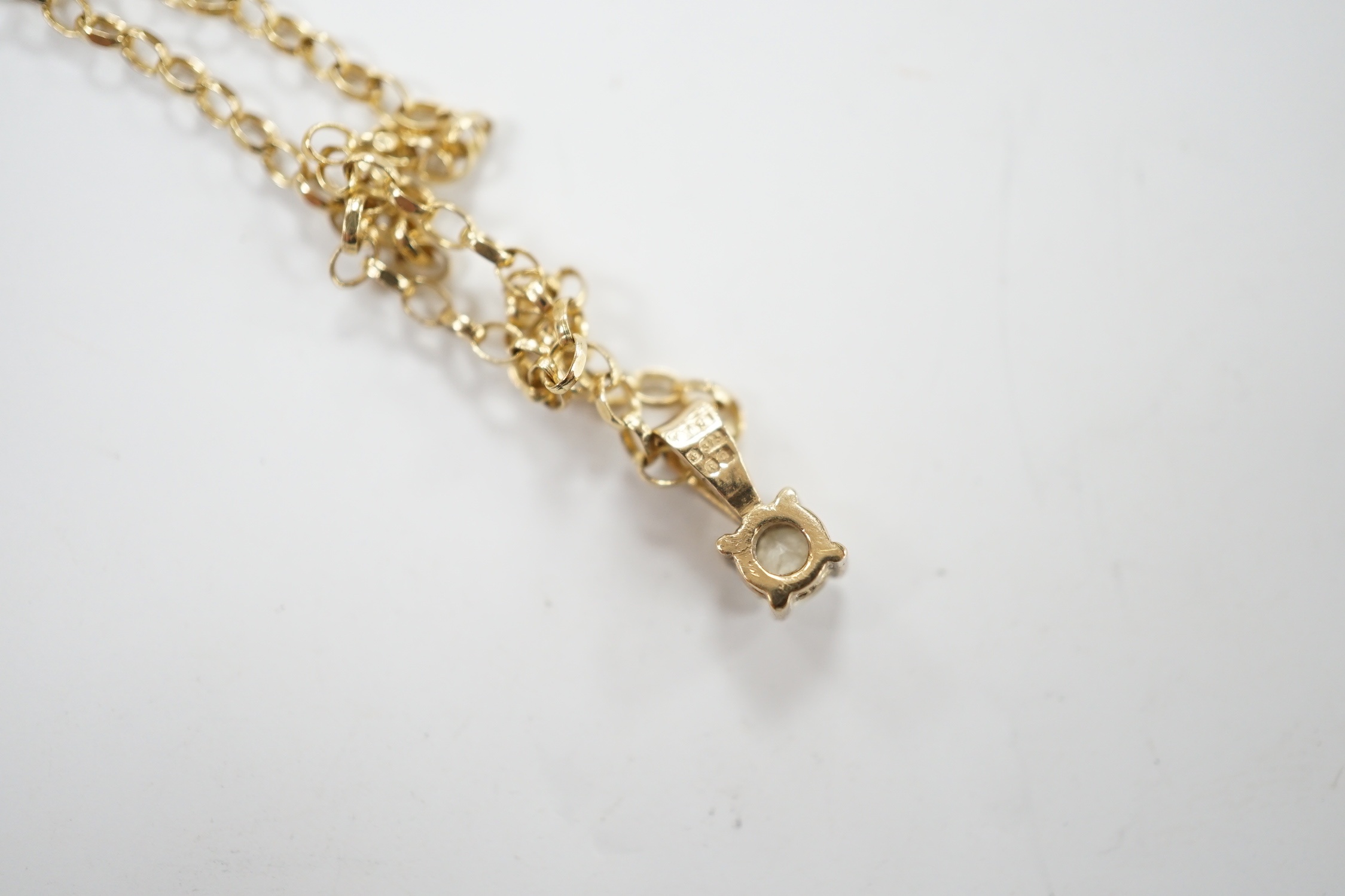 A modern 9ct gold and solitaire diamond set pendant, 9mm, on a 9ct chain, 38cm, gross weight 2.2 grams.